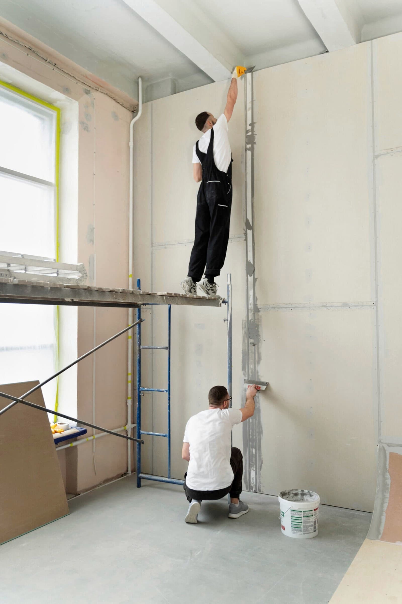 Profissionais instalando placas de gesso acartonado em parede interna