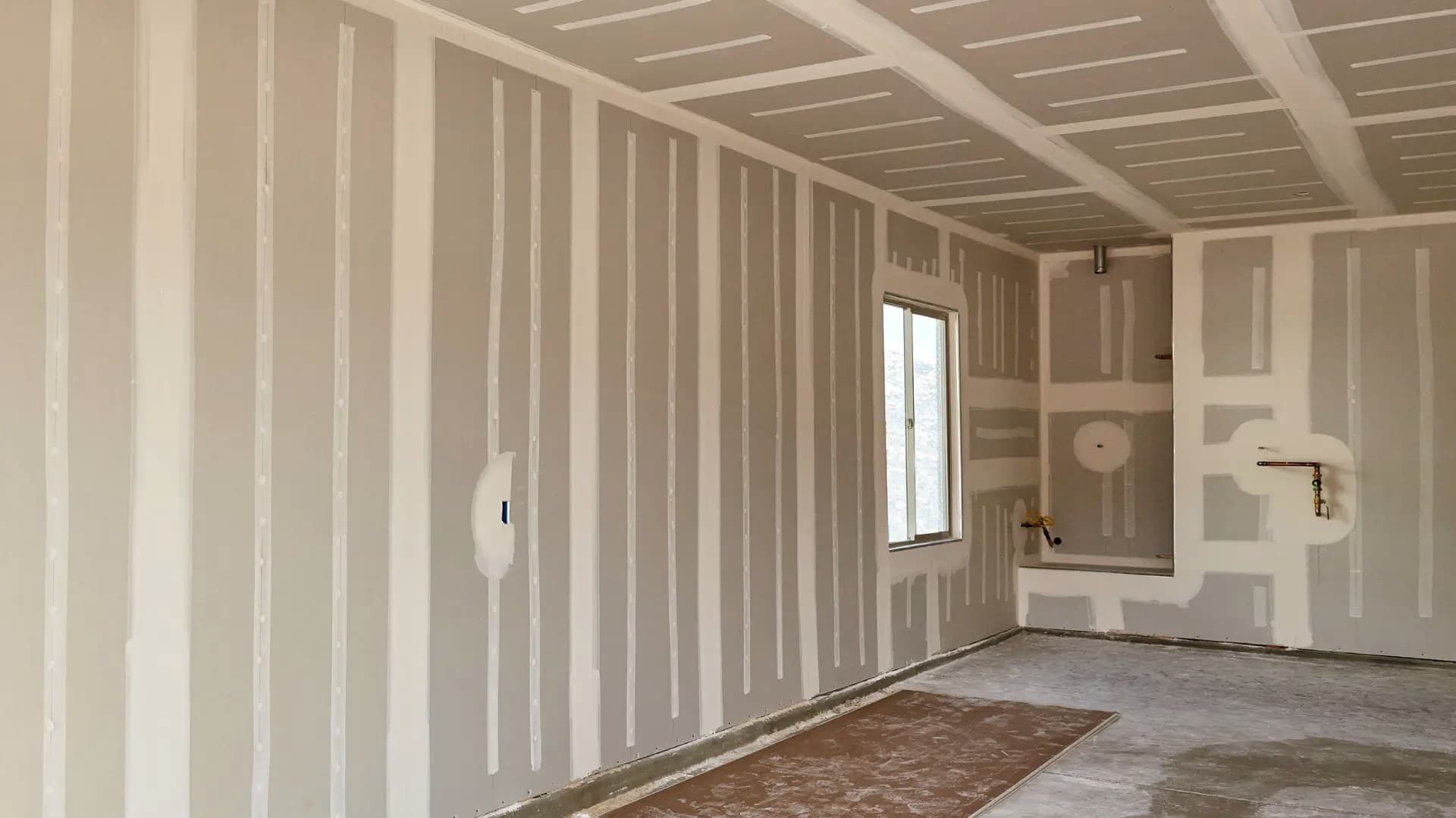 Parede de drywall com juntas tratadas, pronta para pintura