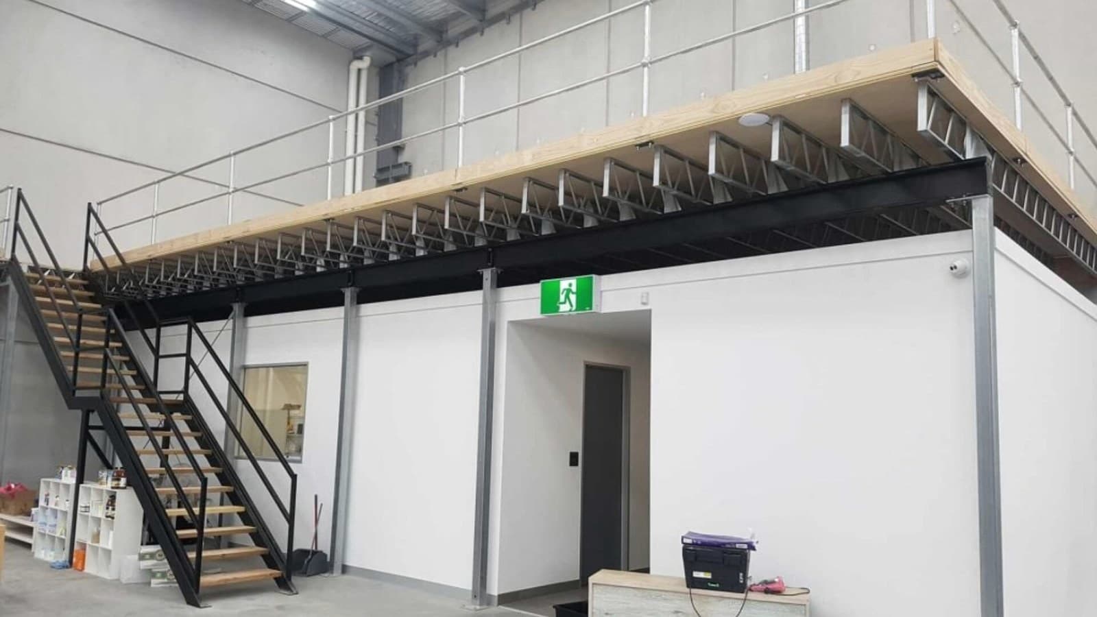 Mezanino em estrutura metálica com escada e guarda-corpo em ambiente interno